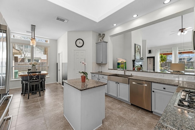 7903 Black Horse Cv, Missouri City, TX 77459 - kitchen with appliances with stainless steel finishes, a sink, a center island, dark stone countertops, and a ceiling fan