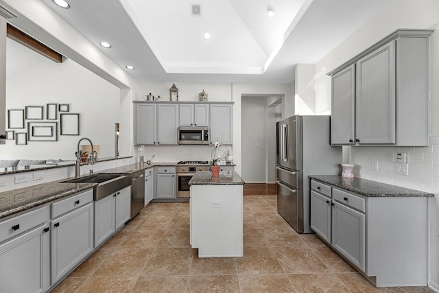 7903 Black Horse Cv, Missouri City, TX 77459 - kitchen with appliances with stainless steel finishes, gray cabinets, dark stone countertops, a sink, and a kitchen island