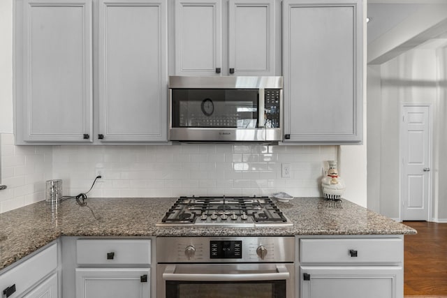 7903 Black Horse Cv, Missouri City, TX 77459 - kitchen featuring appliances with stainless steel finishes, backsplash, dark wood finished floors, and dark stone countertops