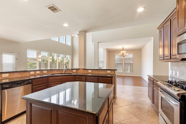 10410 Kingston Creek Ln, Cypress, TX 77433 - kitchen with stainless steel appliances, a sink, a center island, plenty of natural light, and recessed lighting