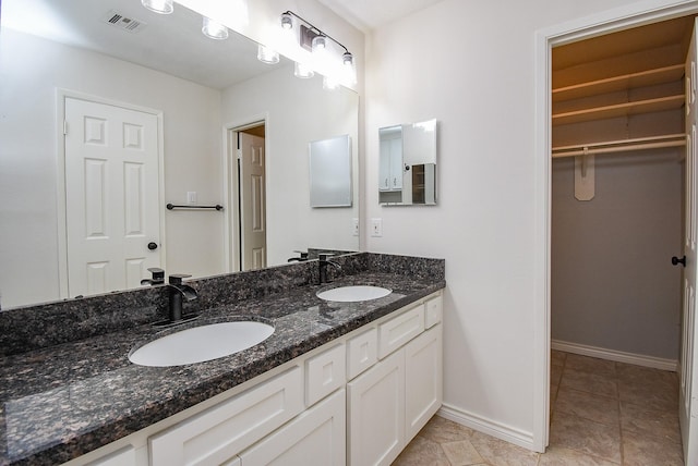 3119 Wagon Trail Dr, Sugar Land, TX 77479 - full bathroom with double vanity, a walk in closet, baseboards, and tile patterned flooring