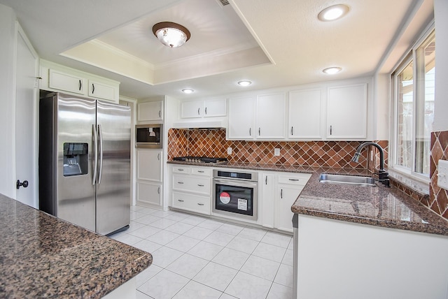 3119 Wagon Trail Dr, Sugar Land, TX 77479 - kitchen with stainless steel appliances, a tray ceiling, a sink, decorative backsplash, and white cabinets