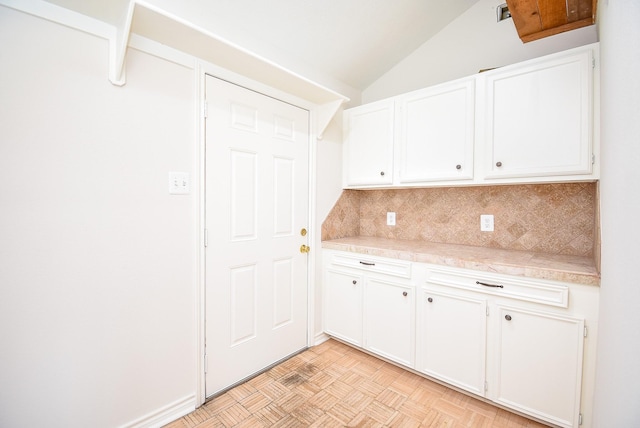 3119 Wagon Trail Dr, Sugar Land, TX 77479 - kitchen with decorative backsplash, light countertops, white cabinets, and vaulted ceiling