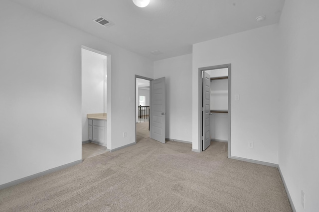 202 Twila Night Ct, Conroe, TX 77318 - unfurnished bedroom with light carpet, a walk in closet, ensuite bath, baseboards, and a closet