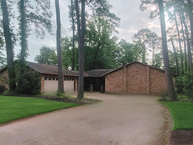 200 El Pinto Dr, Lumberton, TX 77657 - ranch-style home featuring a garage, dirt driveway, brick siding, and a front yard