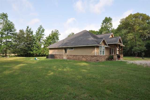 40029 Mill Creek Rd, Magnolia, TX 77354 - view of side of home with brick siding, a yard, a shingled roof, and central AC