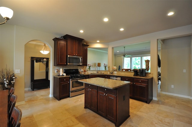 40029 Mill Creek Rd, Magnolia, TX 77354 - kitchen featuring stainless steel appliances, arched walkways, a center island, ceiling fan, and tasteful backsplash