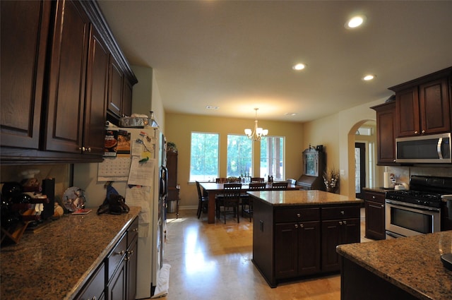 40029 Mill Creek Rd, Magnolia, TX 77354 - kitchen featuring stainless steel appliances, arched walkways, recessed lighting, a chandelier, and a kitchen island