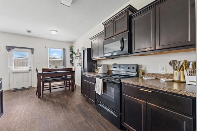 2415 Fallen Pine Ln, Houston, TX 77088 - kitchen featuring black appliances, dark wood-style floors, dark countertops, baseboards, and dark brown cabinetry