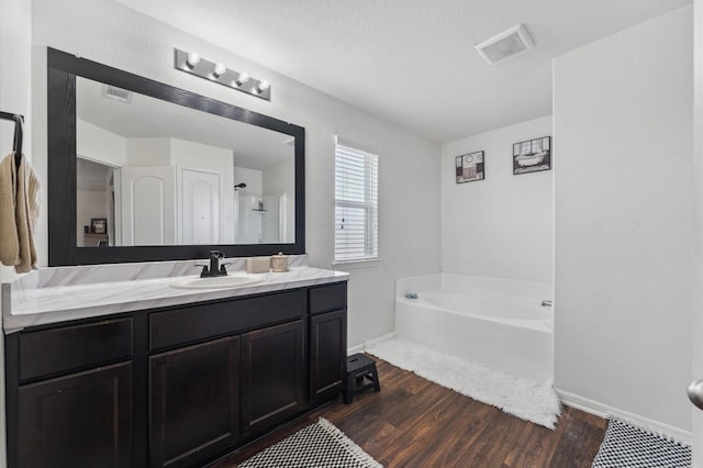 2415 Fallen Pine Ln, Houston, TX 77088 - full bathroom featuring baseboards, wood finished floors, a garden tub, and vanity
