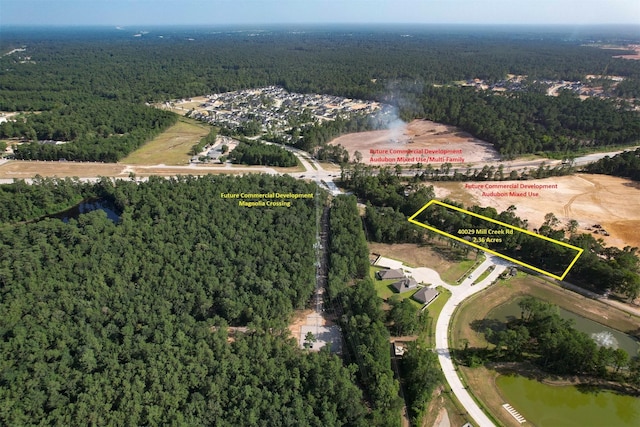 40103 Mill Creek Rd, Magnolia, TX 77354 - aerial view of property and surrounding area featuring a heavily wooded area, property boundaries highlighted, and a nearby body of water