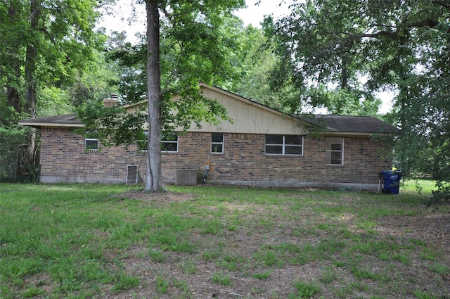 40103 Mill Creek Rd, Magnolia, TX 77354 - view of home's exterior with brick siding, central AC unit, and a chimney