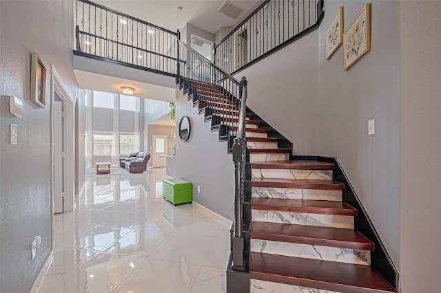 5615 Gemstone Park Rd, Richmond, TX 77407 - staircase featuring a towering ceiling, marble tiled floors, and baseboards