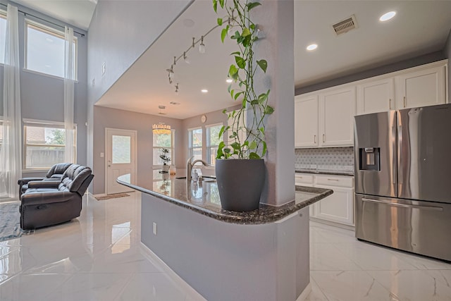 5615 Gemstone Park Rd, Richmond, TX 77407 - kitchen with stainless steel refrigerator with ice dispenser, dark stone counters, light marble finish flooring, open floor plan, and white cabinetry