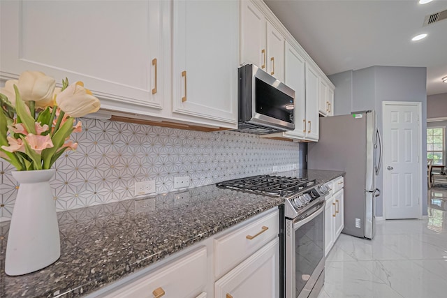 5615 Gemstone Park Rd, Richmond, TX 77407 - kitchen with stainless steel appliances, white cabinetry, tasteful backsplash, dark stone counters, and light marble finish floors