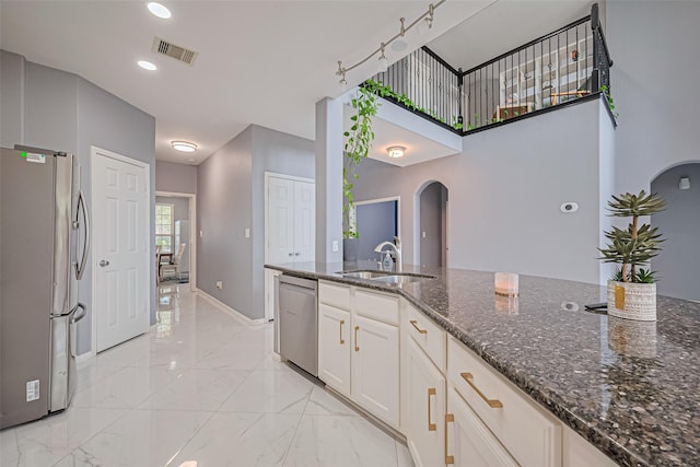 5615 Gemstone Park Rd, Richmond, TX 77407 - kitchen with stainless steel appliances, a sink, arched walkways, light marble finish floors, and recessed lighting