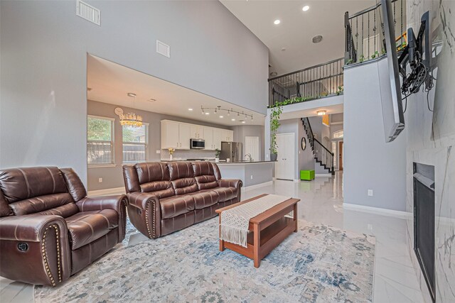 5615 Gemstone Park Rd, Richmond, TX 77407 - living area with baseboards, a towering ceiling, recessed lighting, stairs, and light marble finish flooring