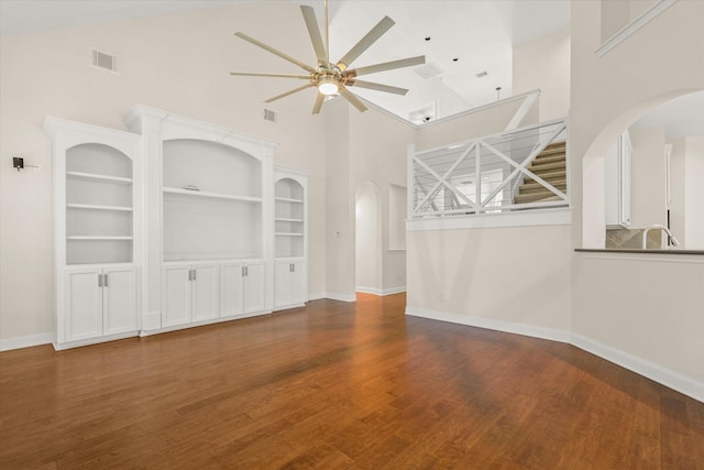 5122 Hidden Brook Ln, League City, TX 77573 - unfurnished living room featuring high vaulted ceiling, ceiling fan, wood finished floors, baseboards, and arched walkways