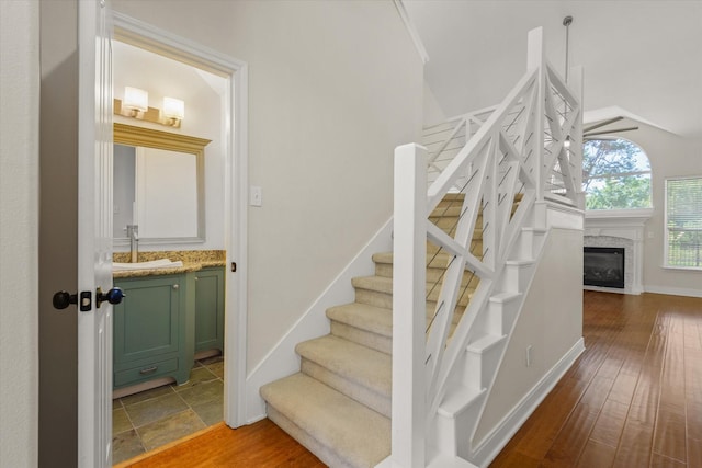 5122 Hidden Brook Ln, League City, TX 77573 - staircase featuring baseboards, a glass covered fireplace, and wood finished floors