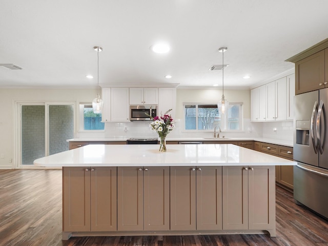 5402 Girnigoe Dr, Houston, TX 77084 - kitchen featuring appliances with stainless steel finishes, a sink, a kitchen island, backsplash, and crown molding