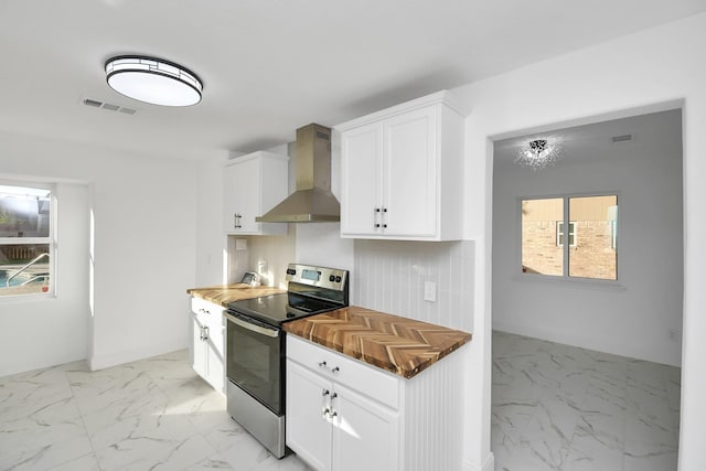 6035 Cartagena St, Houston, TX 77035 - kitchen with stainless steel electric stove, wall chimney range hood, light marble finish flooring, and wood counters