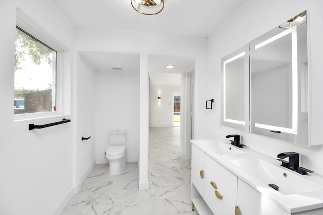 6035 Cartagena St, Houston, TX 77035 - bathroom with marble look tiles, double vanity, baseboards, and toilet