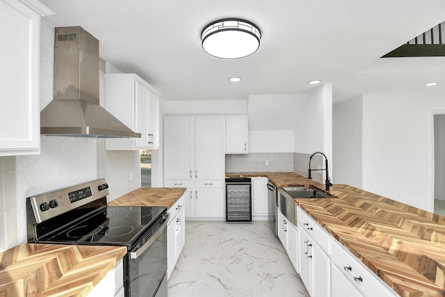 6035 Cartagena St, Houston, TX 77035 - kitchen featuring stainless steel appliances, wall chimney exhaust hood, butcher block counters, a sink, and recessed lighting