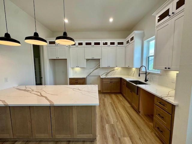 1631 Beall St, Houston, TX 77008 - kitchen with a sink, light wood-type flooring, light stone counters, glass insert cabinets, and white cabinetry