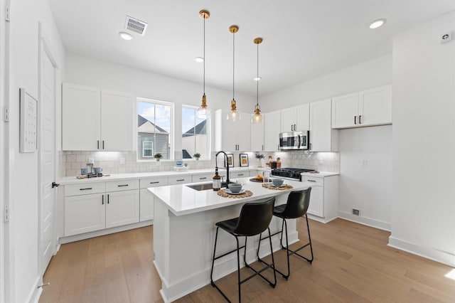 8303 Springwood Creek Ln, Houston, TX 77055 - kitchen featuring stainless steel microwave, tasteful backsplash, white cabinetry, and recessed lighting