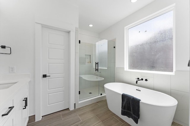 8303 Springwood Creek Ln, Houston, TX 77055 - bathroom featuring a freestanding bath, a shower stall, vanity, recessed lighting, and tile walls