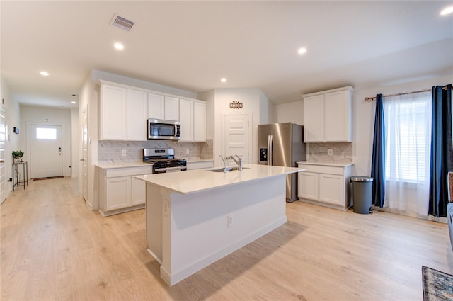 31814 Hallington Hill Ln, Fulshear, TX 77441 - kitchen featuring stainless steel appliances, a sink, decorative backsplash, light countertops, and a kitchen island with sink