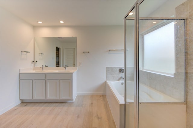31814 Hallington Hill Ln, Fulshear, TX 77441 - bathroom with wood finished floors, a garden tub, double vanity, baseboards, and recessed lighting