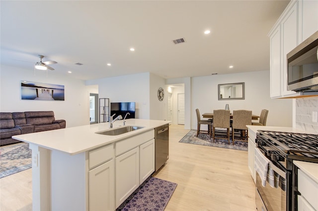 31814 Hallington Hill Ln, Fulshear, TX 77441 - kitchen featuring appliances with stainless steel finishes, a sink, open floor plan, light wood-style flooring, and recessed lighting