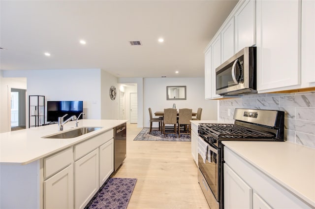 31814 Hallington Hill Ln, Fulshear, TX 77441 - kitchen with stainless steel appliances, a sink, tasteful backsplash, light countertops, and recessed lighting