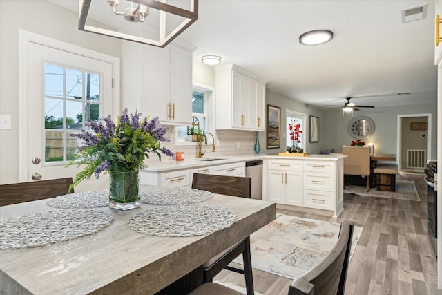 14022 Roundstone Ln, Houston, TX 77015 - kitchen featuring a peninsula, light countertops, a sink, white cabinetry, and light wood-type flooring