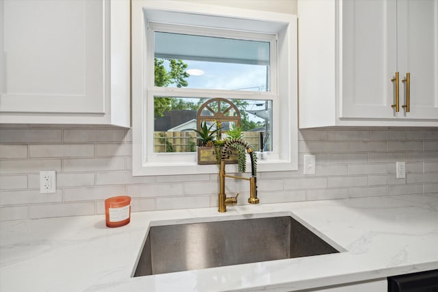 14022 Roundstone Ln, Houston, TX 77015 - kitchen with a sink, white cabinets, light stone counters, tasteful backsplash, and dishwasher