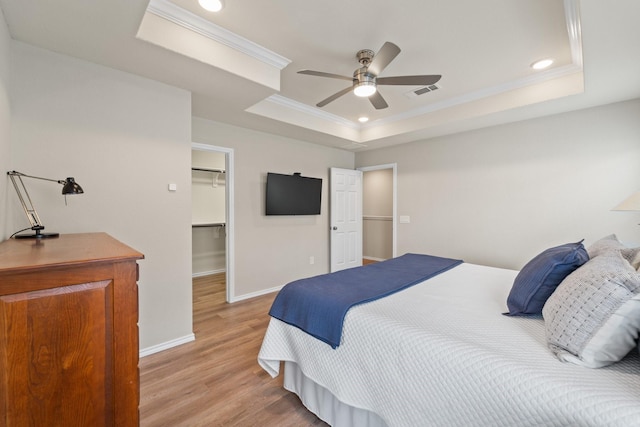 8957 Monterey View Dr, Houston, TX 77080 - bedroom with a raised ceiling, ornamental molding, light wood finished floors, baseboards, and a walk in closet