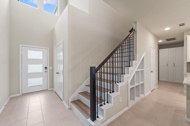 8957 Monterey View Dr, Houston, TX 77080 - foyer entrance featuring stairs, baseboards, a towering ceiling, recessed lighting, and light tile patterned flooring