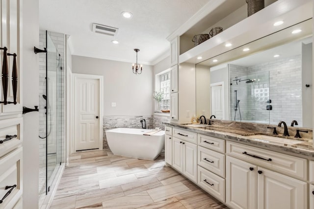 11802 Guernsey Dr, Tomball, TX 77377 - bathroom with a shower stall, tile walls, ornamental molding, recessed lighting, and double vanity