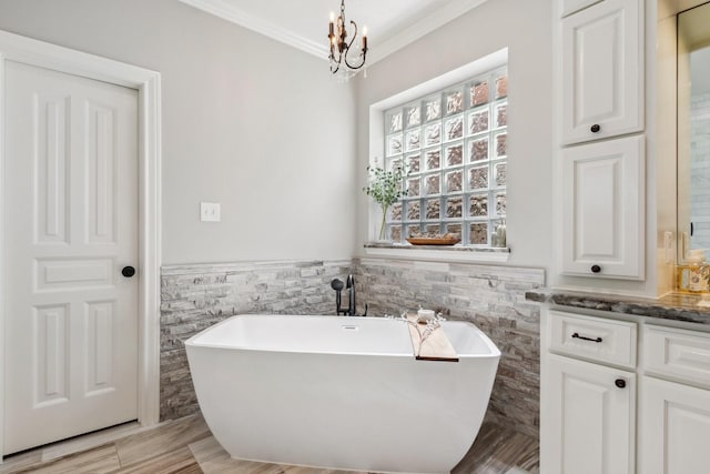 11802 Guernsey Dr, Tomball, TX 77377 - bathroom with tile walls, crown molding, a soaking tub, a chandelier, and wainscoting