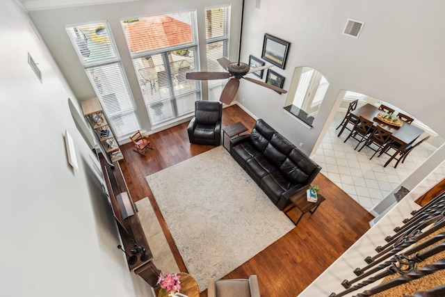 11802 Guernsey Dr, Tomball, TX 77377 - living room with healthy amount of natural light, wood finished floors, a ceiling fan, and arched walkways