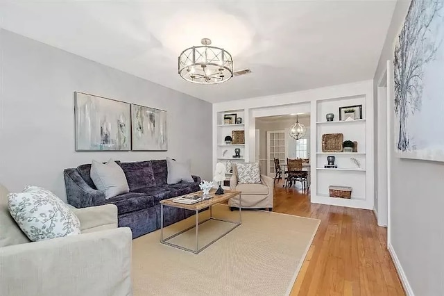 1062 Lamonte Ln, Houston, TX 77018 - living area featuring a chandelier, built in shelves, light wood-type flooring, and baseboards