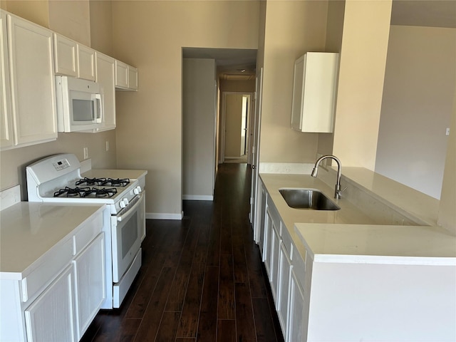 19638 Plantation Grove Trl, Katy, TX 77449 - kitchen with white appliances, a sink, dark wood-type flooring, white cabinetry, and baseboards