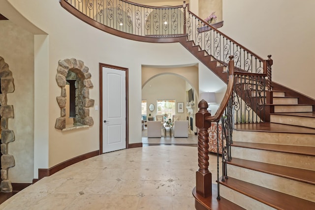 14 Royal King Rd, Tomball, TX 77377 - entrance foyer featuring arched walkways, a towering ceiling, baseboards, and stairs