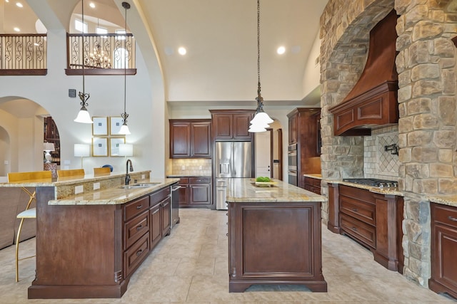 14 Royal King Rd, Tomball, TX 77377 - kitchen featuring a kitchen island with sink, stainless steel appliances, high vaulted ceiling, a sink, and arched walkways