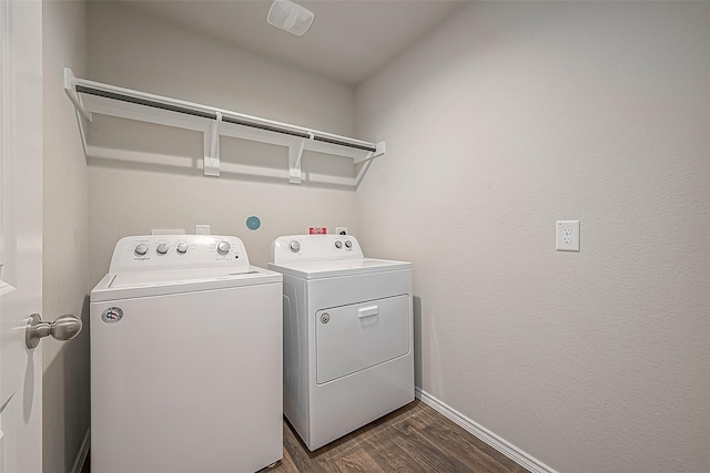 clothes washing area with independent washer and dryer, dark wood-style flooring, and baseboards