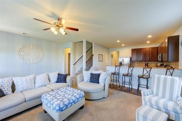 living area with a ceiling fan, recessed lighting, and stairway