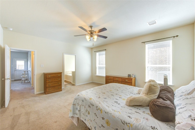 bedroom featuring multiple windows, light colored carpet, ceiling fan, and baseboards