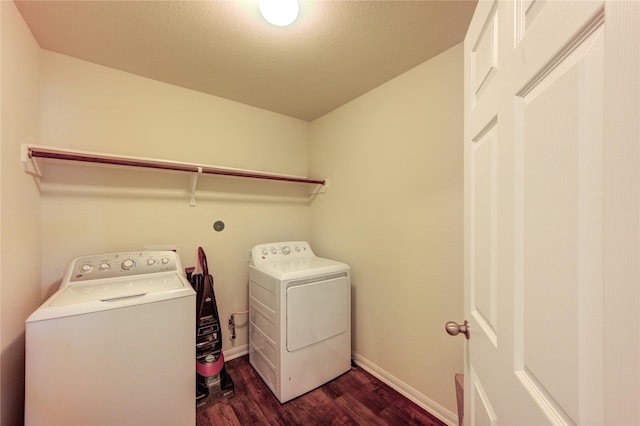 laundry room featuring dark wood finished floors, washer and dryer, and baseboards
