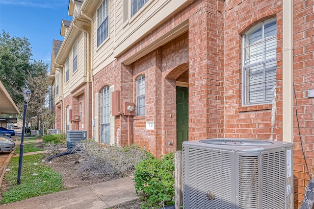 2710 Grants Lake Blvd Unit L8, Sugar Land, TX 77479 - view of exterior entry featuring central air condition unit and brick siding